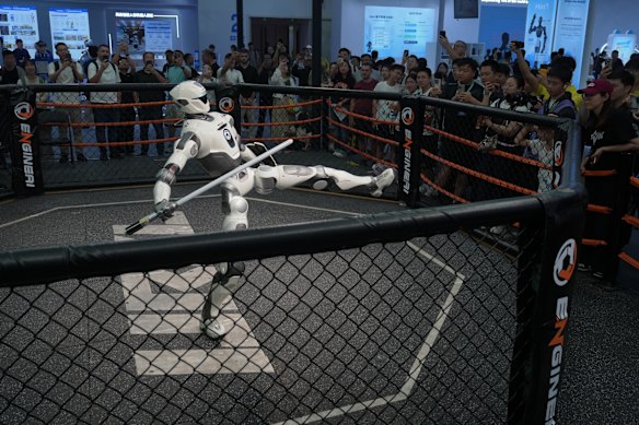 Visitors watch a humanoid robot perform during the World Robot Conference.