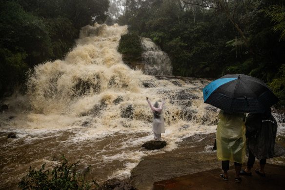 Tourists enter dangerous floodwaters at Katoomba Falls on Friday afternoon. 