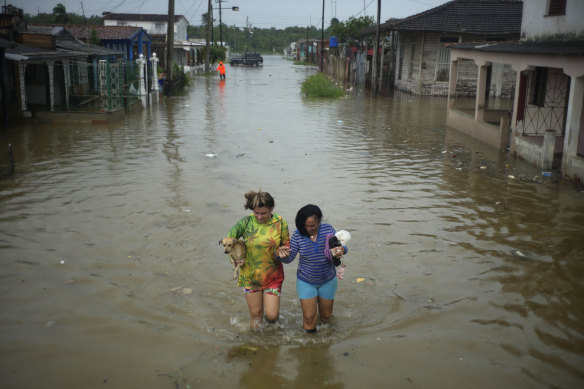 Residents wade through a street flooded by rains brought on by Hurricane Idalia