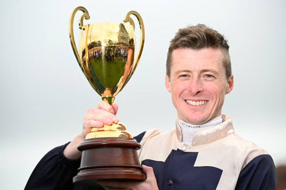 Harry Coffey poses with the trophy after riding Duke De Sessa to the Caulfield Cup