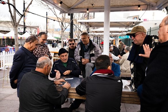 Men enjoy a game of dominoes at Macquarie Street Mall.