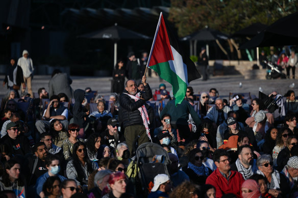 The Palestinian flag flies over a vigil in Melbourne’s Federation Square.