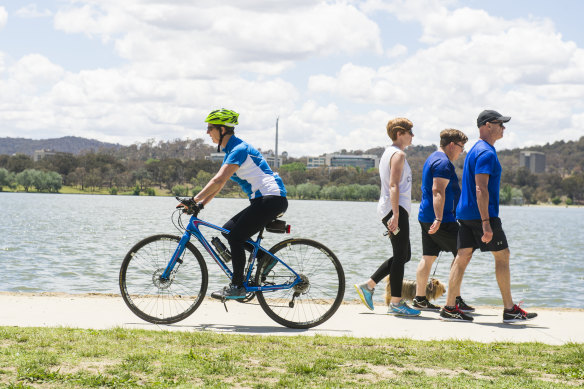 Cyclist from Pedal Power Michelle Weston passes a group of people along the busy lakeside path next to Bowen Park.