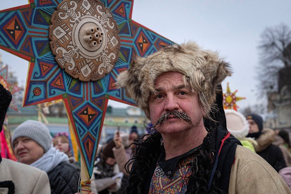 A man wearing a national costume celebrates Christmas near St. Michael Monastery in a city centre in Kyiv, Ukraine.