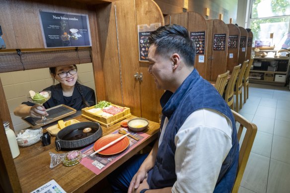 Servers lift the blinds to deliver dishes to solo diners.