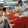 Customers at a produce market in Beijing.