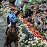 Jamie Melham throws her race goggles into the crowd after winning the Melbourne Cup on Half Yours.