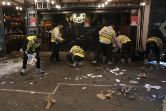 Members of Israeli Zaka Rescue and Recovery team cleans blood from the site of Thursday’s shooting in Tel Aviv, Israel.