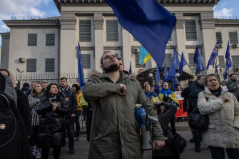 People sing the Ukrainian national anthem during a protest outside the Russian embassy in Kyiv, Ukraine. 