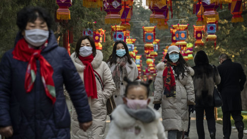 Women and a child wear protective masks in Beijing, China, on Saturday.