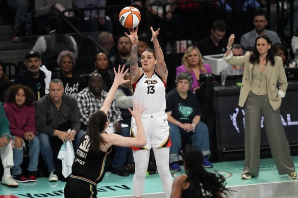 Cayla George shoots a three-point shot with New York coach Sandy Brondello (back right) watching on.