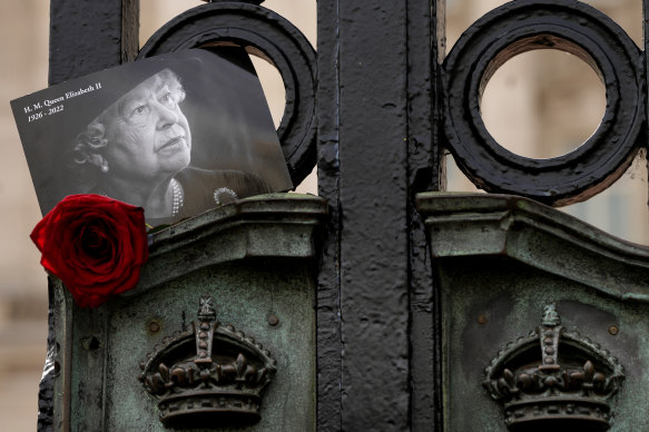 A tribute to the late Queen Elizabeth II is tucked into the gates of Buckingham Palace in London.
