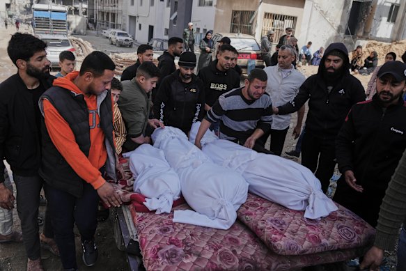 Palestinians accompany the bodies of their relatives killed in an Israeli airstrike, loaded onto a cart in preparation for burial, at Shifa Hospital in Gaza City on Wednesday.