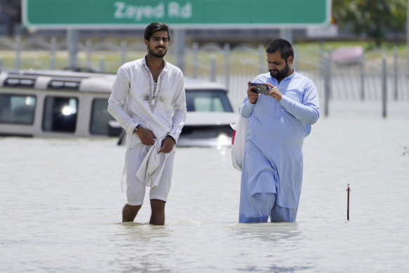 Men walk through floodwater in Dubai this week.