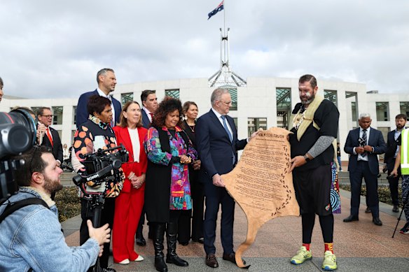 Prime Minister Anthony Albanese is presented with a letter written on kangaroo skin, urging the creation of a national truth-telling process, by Travis Lovett, former deputy chair of the Yoorrook Justice Commission.