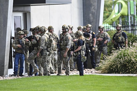 Law enforcement officers prepare to sweep a building at the university.