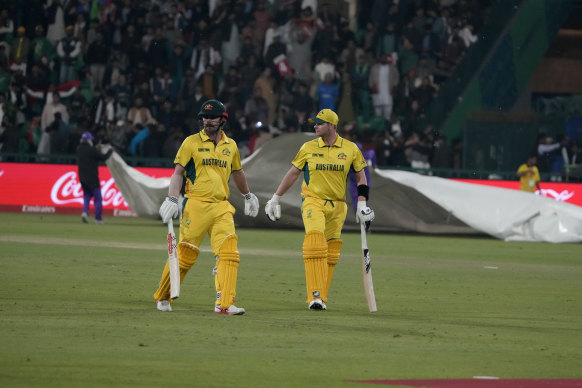 Australia’s Steve Smith, right, and Travis Head walk off the field after rain stops the play.