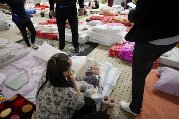 A refugee who fled the conflict from neighbouring Ukraine sits next to her son Maxim, 5 months old, in the hall of a hotel offering shelter in Siret, Romania.