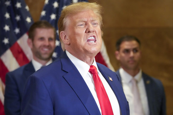 Eric Trump, back left, smiles as former president Donald Trump thanks supporters who were cheering him on after his court appearance at a news conference in New York.