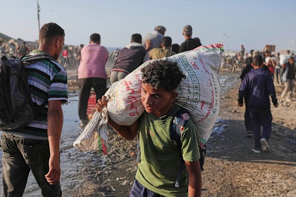 A girl palestinate brings a lot of food and humanitarian aid unloaded by a world food program.