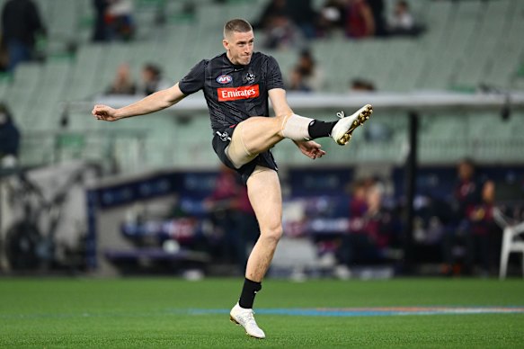 Darcy Cameron of the Magpies warms up.