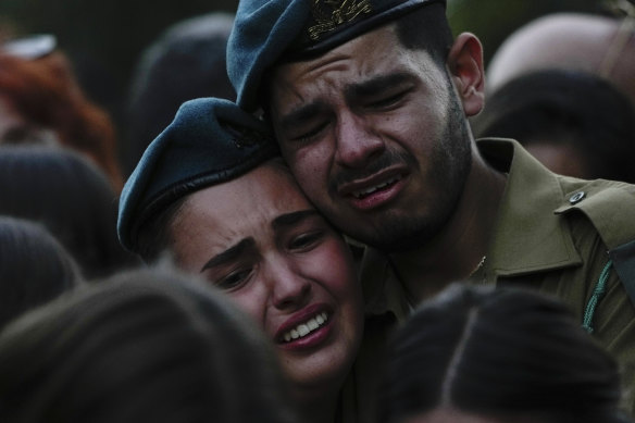 Israeli soldiers cry during the funeral of those killed by Hamas militants in a kibbutz.