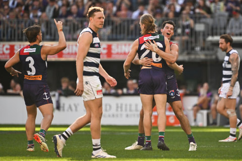 Cats defender Mitch Duncan looks on as Jaeger O’Meara and Hayden Young celebrate a Fremantle goal.