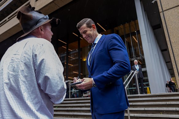Roberts-Smith signs an autograph for a supporter outside the Federal Court in Sydney on Friday.