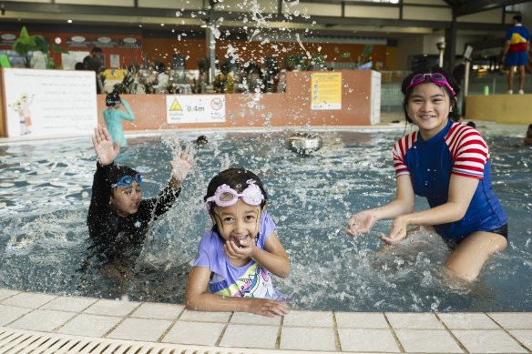 Aiden and Hermione Kumar and Sophia Acosta play after their swimming lessons at Blacktown Leisure Centre. 