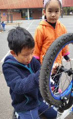 Budding mechanic Huy Ho, 8, from Flemington Primary School repairs a bike.