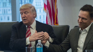 Then US President-elect Donald Trump, left, speaks while Peter Thiel, billionaire co-founder of PayPal Inc. and a member of Donald Trump’s transition team, listens.