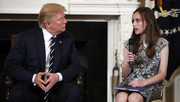 President Donald Trump listens to Carson Abt, a student at Marjory Stoneman Douglas High School as he hosts a listening session with high school students and teachers in the State Dining Room of the White House in Washington.