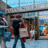 Shoppers walk pass the World of Ralph Lauren in Taiku Li Sanlitun, a popular shopping and dining area in Beijing.