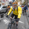 Cyclists ride along a protected bike lane in the city.