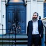 Rabbi Dovid Gutnick stands outside the charred front door of the East Melbourne synagogue on Saturday morning.