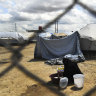 A woman washes her clothes in the al-Hawl camp in 2019.