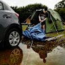 Jack Sultana packs up his rain-soaked camp site at Bents Basin State Conservation Area near Wallacia on Friday.