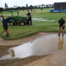 Workers drain a bunker as play is suspended during the Australian PGA at Royal Queensland Golf Club in Brisbane.