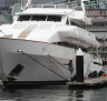 A deckhand cleans the hull of Solomon Lew’s superyacht Texas in Victoria Harbour