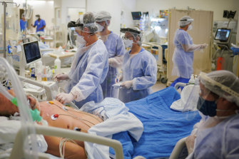 Health workers tend to a COVID-19 patient in the ICU ward at the Hospital das Clinicas in Porto Alegre, Brazil.