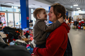 A woman who fled the war in Ukraine comforts a child at a temporary shelter in Krakow, Poland.