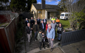 Micaela, front left, with baby daughter Harper, Brother Harry Prout, front right, and some of the 60 volunteers and donors, at one of four renovated Heidelberg West houses.  
