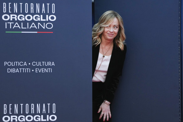 Italy’s Prime Minister Giorgia Meloni peers out from a door before introducing Britain’s Prime Minister Rishi Sunak.