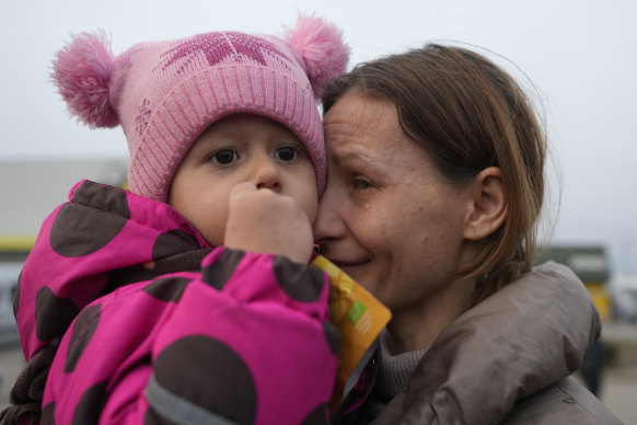 A woman with a child who fled from the war in Ukraine are reunited with their family after crossing the border in Medyka, Poland.