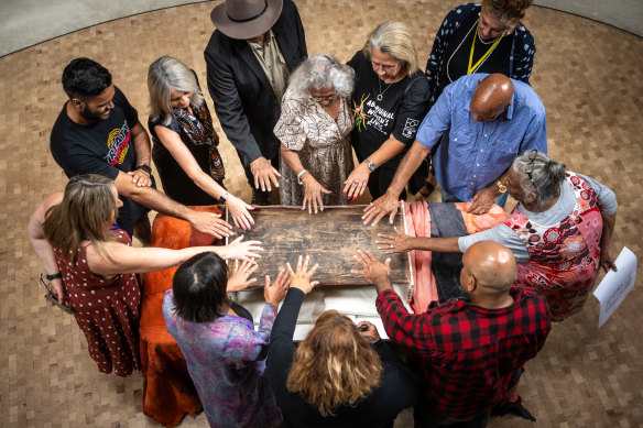 Elders and traditional owners with the bark ethcing on Saturday.