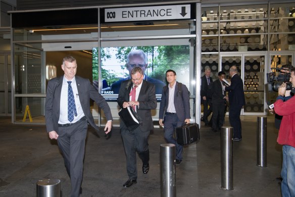 AFP officers depart the ABC studios at about 8.20pm on Wednesday evening after taking documents.