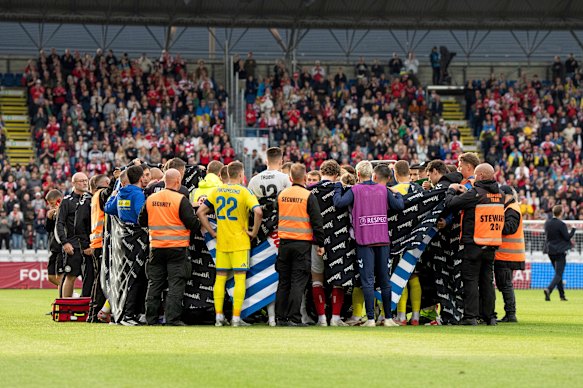 Denmark and Ukraine players form a circle around Christian Eriksen after he collapsed during their international friendly in Odense.