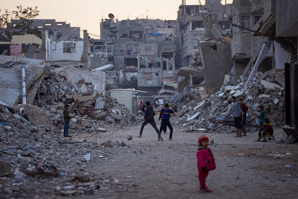 Palestinian children playing near the buildings destroyed by Israeli army attacks in Khan Younis, Gaza. The reconstruction of the area will be carried out over a period of ten years or more.