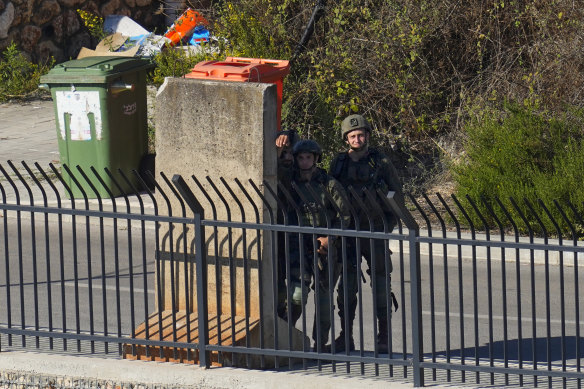 Israeli soldiers take positions alongside the border in the Israeli town of Metula, as seen from the Lebanese side of the Lebanese-Israeli border in the southern village.