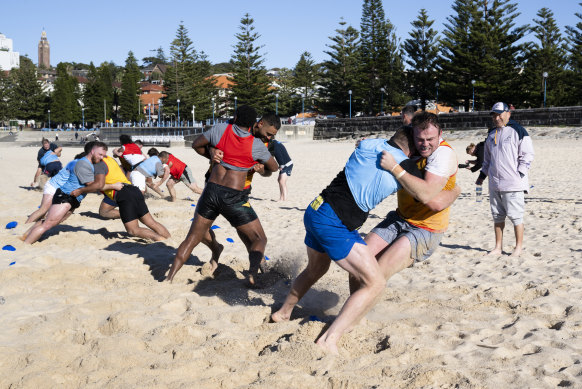 Wallabies forwards bash each other in one-on-one wrestling drills.
